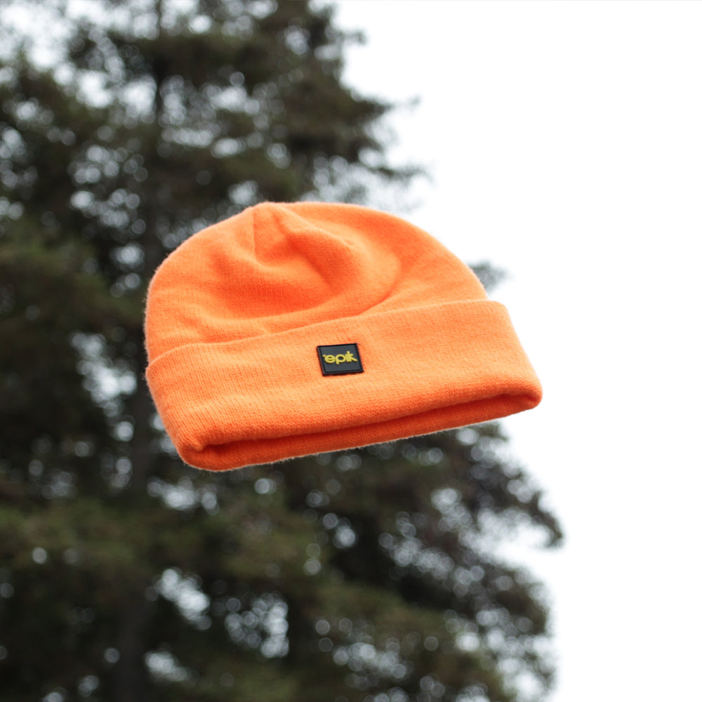 Epik Workwear Orange Beanie Thrown in the air